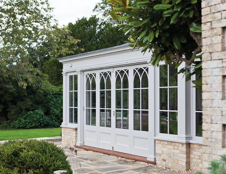 Gothic arched folding doors on the side of an orangery